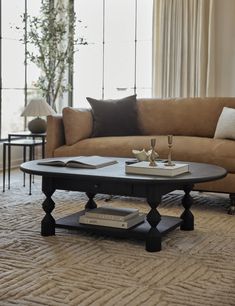 a living room with a couch, coffee table and two candles on the end tables