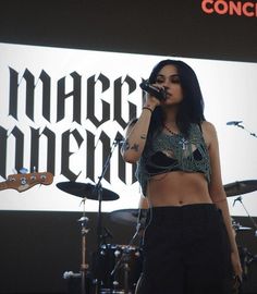 a woman standing on top of a stage holding a microphone