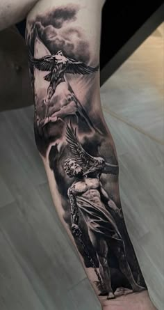 a man's leg with a tattoo on it that has an image of jesus holding the cross