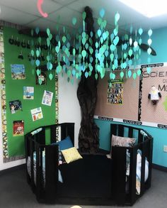 a baby crib with paper hearts hanging from it's ceiling in an office