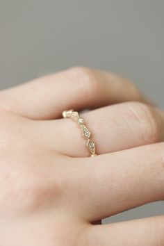 a woman's hand with a gold ring on it and diamond band in the middle