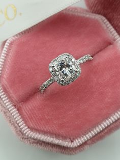 an engagement ring in a pink velvet box