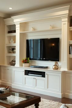 a living room with built in shelves and a flat screen tv