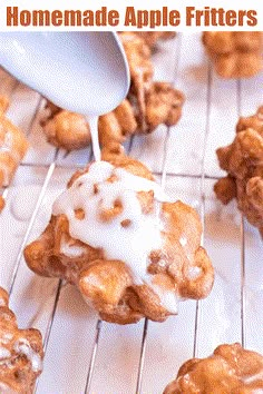 a spoon drizzling icing onto some pastries on a cooling rack