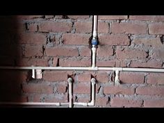 pipes are lined up against a brick wall