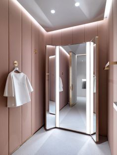 an empty bathroom with pink walls and mirrors