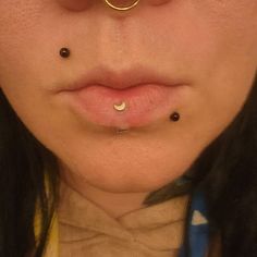 a woman with piercings on her nose and nose ring in front of her face