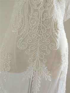 the back of a white dress with beading on it