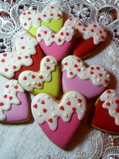 several decorated heart shaped cookies on a lace doily