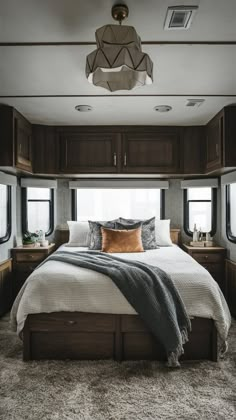 a bedroom with a bed, nightstands and windows