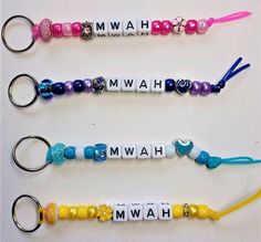 three personalized keychains with name charms attached to them, all in different colors