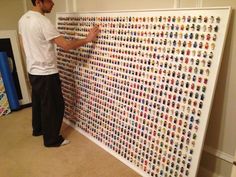 a man standing next to a wall covered in legos