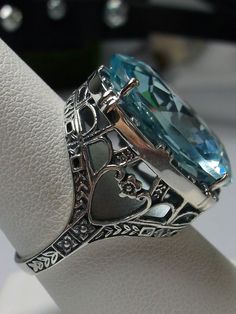 24ct. Simulated Aquamarine Sterling Silver RingOval Beast Design#D76 This is a new beautiful Victorian reproduction ring cast in solid sterling silver. The gorgeous filigree ring is set with a huge approximately 24 carat simulated blue aquamarine gemstone. The stunning gem is 17mm (11/16") wide x 23mm(15/16") long. The ring is 12mm off the finger. The inside of the band is marked 925 for sterling silver. Notice the craftmanship of the sterling silver setting. The large stone is accented by the b Beast Design, Luxury Jewelry Box, Antique Filigree, Filigree Jewelry, Blue Ring, Large Stone, Cameo Ring, Aquamarine Ring, Jewelry Antique