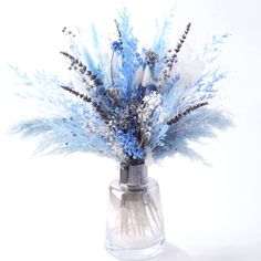 a glass vase filled with blue flowers on top of a table