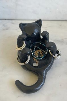 a black cat figurine with jewelry on it's back