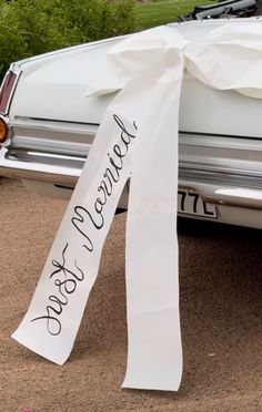 a white car with a ribbon tied around it's front end and the words, because not for us