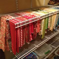 a rack filled with lots of colorful scarves on top of metal shelves in a room