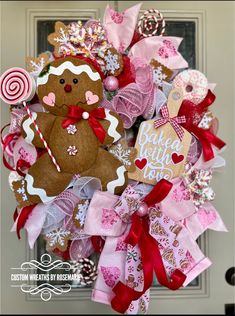 a christmas wreath with a gingerbread man and candy canes on the front door