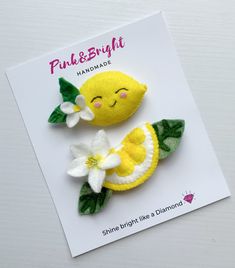 two felt lemons with leaves and flowers sitting on top of a white card that says pink & bright handmade