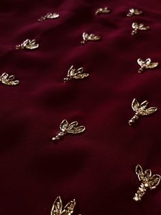 gold brooches on a maroon fabric