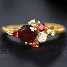 a red and white diamond ring on a black surface