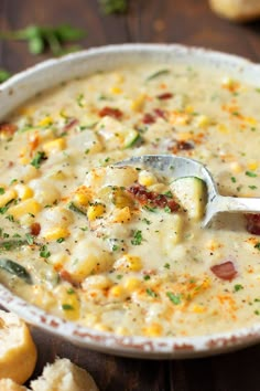 a white bowl filled with corn chowder next to crackers