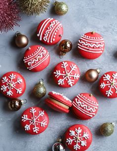 red and white decorated christmas ornaments on a gray surface next to some silver ornament