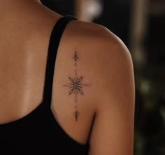 the back of a woman's shoulder with a star tattoo on her left arm