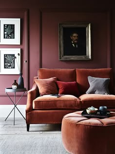 an orange couch and ottoman in a living room with pink walls, white trim and flooring