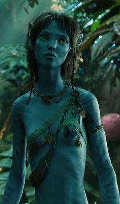 a woman with blue paint on her body in the jungle