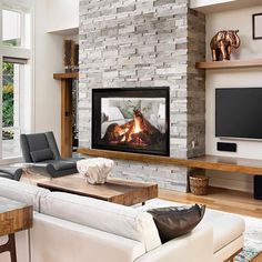 a living room filled with furniture and a fire place in the middle of it's wall