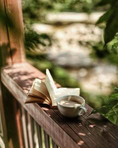 a cup of coffee and an open book on a deck