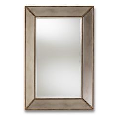 a mirror that is sitting on top of a white wall and has beaded trim around the edges