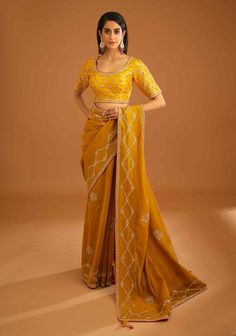 Editor's Note A mustard yellow zardozi embroidered dupion silk sari and blouse would be a stunning choice for a traditional event or wedding. The rich and vibrant color paired with intricate zardozi embroidery would make for a gorgeous and elegant ensemble. Color: Mustard yellow Fabric: Dupion silk & chanderi Embroidery details: Zardozi embroidery Components: Sari & blouse Sari length: 6 meters, sari width: 46" inches Occasion: Festive and Wedding Guest Disclaimer: Product color may slightly var Yellow Sari, Blouse Sari, Blouse Yoke, Zardozi Embroidery, Personal Shopping Service, Casual Tunics, Dupion Silk, Sari Blouse, Silk Sari