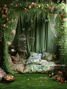 a bed covered in lush green curtains next to a birdcage filled with flowers