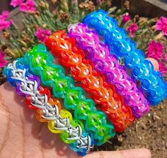 a hand holding several different colored bracelets