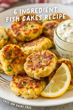 crab cakes on a white plate with lemon wedges and ranch dip in the background