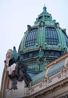 the top of a building with a statue on it's roof and an ornate dome