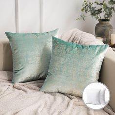 two pillows sitting on top of a white couch