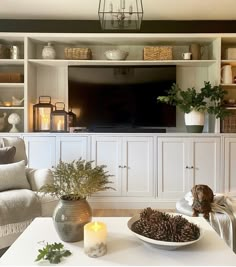 a living room filled with furniture and a flat screen tv mounted to the side of a wall