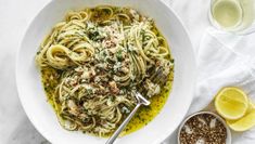 a white bowl filled with pasta and garnished with parmesan cheese on top