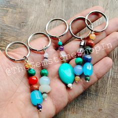 a person holding four different colored beads in their hand