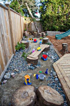 an outdoor play area with rocks and toys