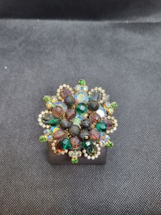 Vintage woman's flower brooch with jewels and beads. Formal Costume Jewelry Brooches With Sparkling Stones, Elegant Multicolor Brooches For Evening, Jeweled Evening Costume Jewelry Brooches, Multicolor Brooch For Evening Wear, Formal Costume Jewelry Pins, Multicolor Brooch Jewelry For Evening, Flower Shaped Party Brooch, Party Flower Shaped Brooch Jewelry, Party Brooches With Flower Shape And Rhinestones