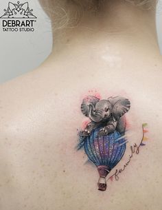 an elephant tattoo on the back of a woman's upper back shoulder and neck