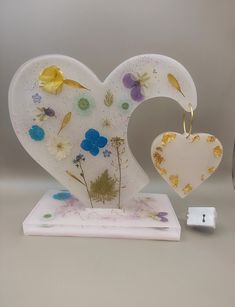 a heart shaped glass decoration with flowers on it and a charger next to it