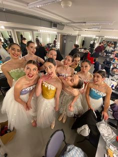 a group of young ballerinas posing for a photo in front of the camera