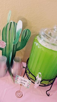 a table topped with green juice and cactus decorations