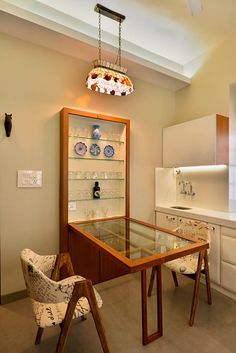 a dining room table and chairs in front of a glass display case