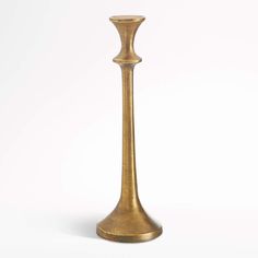 a tall gold colored candle holder on a white background with no one around it to see the light